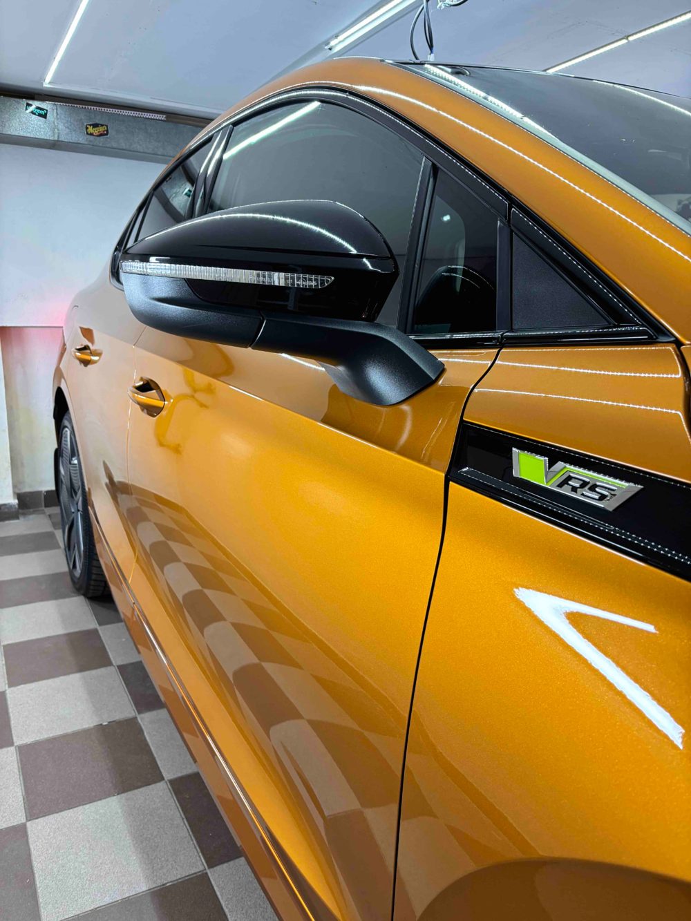 Oranžová Škoda RS s vyleštěným lakem v dílně